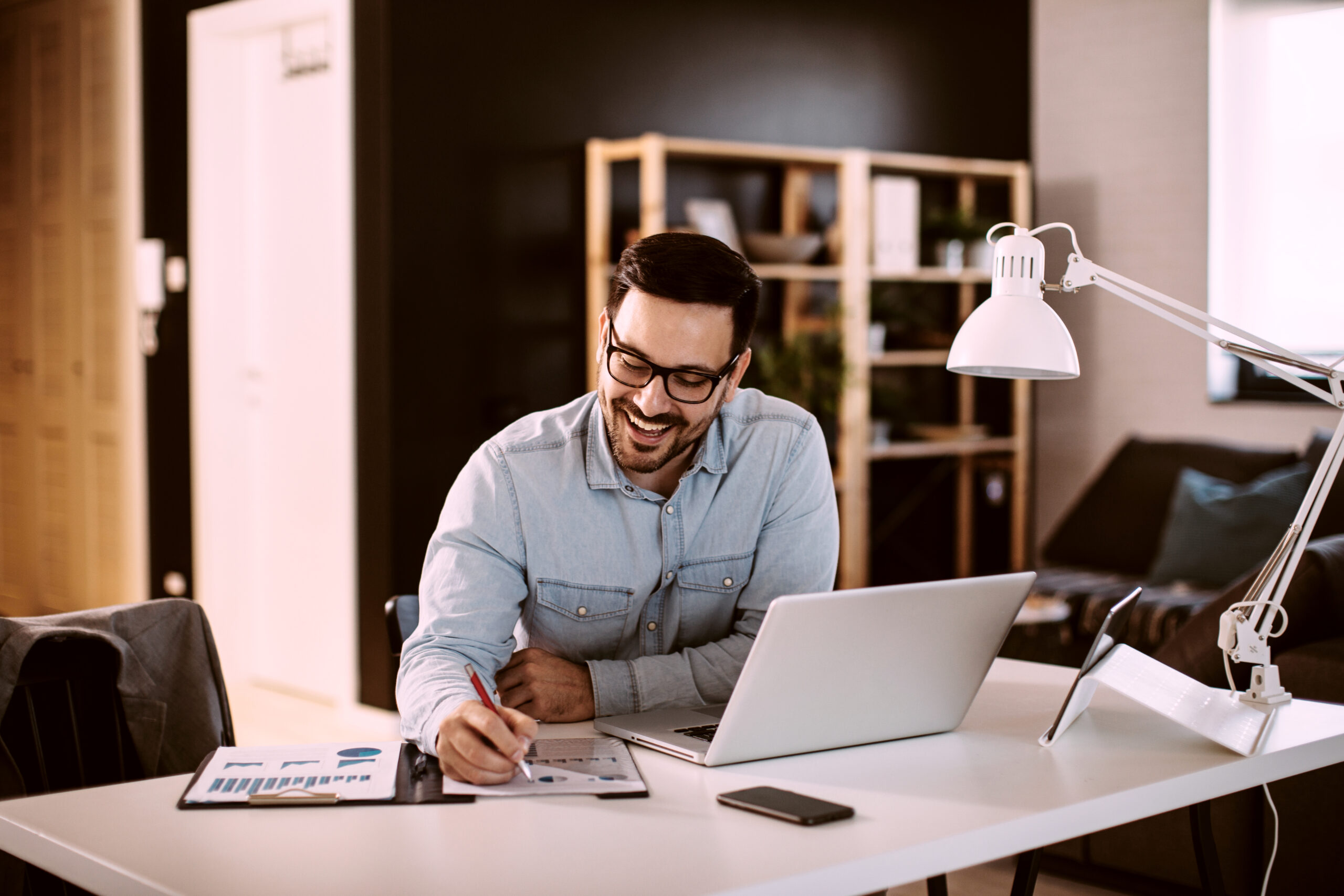 Young business man working at home with laptop and papers on desk; Shutterstock ID 1654831870; Project_Name: Cyber security; Department : Industries; Name: Sarah Baird; Date: 28/05/2021